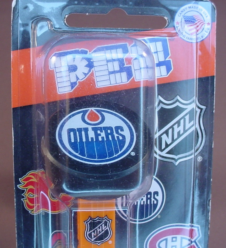 Pez NHL Hockey Edmonton Oilers Logo On A Black Puck, In The Original Packaging, Orange Stem With The NHL Logo, Pez Candy Dispenser