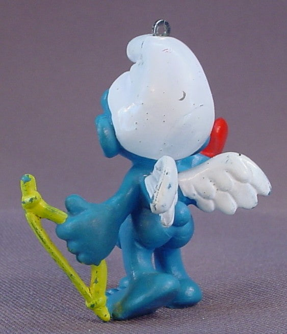 Amour Or Cupid Smurf With A Thin Yellow Bow & A Red Heart PVC Figure, #20128, 1981 Peyo Schleich, W. Germany, Has An Ornament Loop In The Top Of The Head, Smurfs, Vintage, Figurine