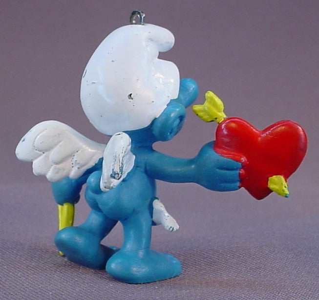 Amour Or Cupid Smurf With A Thin Yellow Bow & A Red Heart PVC Figure, #20128, 1981 Peyo Schleich, W. Germany, Has An Ornament Loop In The Top Of The Head, Smurfs, Vintage, Figurine