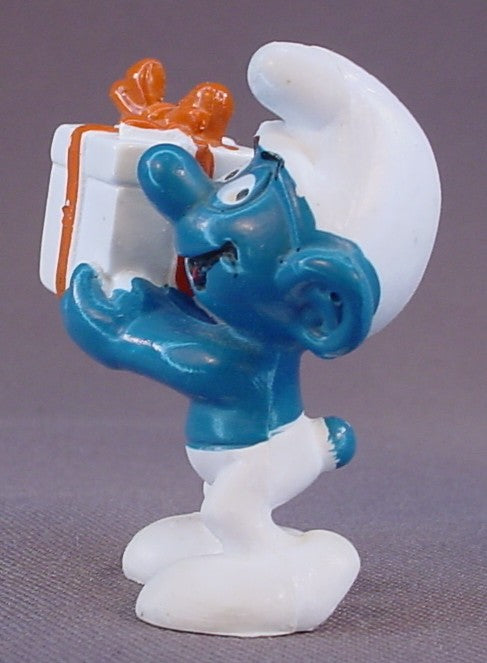 Gift Smurf Carrying A White Present With An Orange Bow PVC Figure, #20086, 1975 Peyo Bully, Made In Hong Kong, Smurfs, Vintage, Figurine