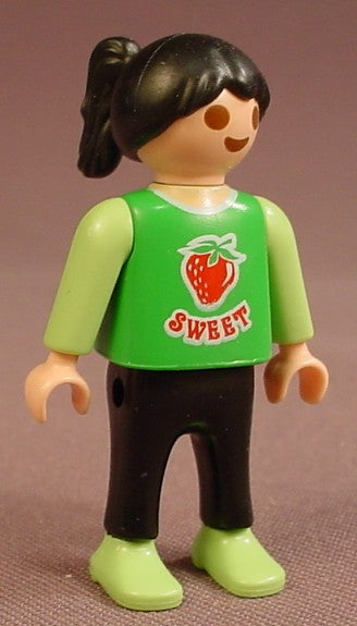 Playmobil Female Girl Child Figure In A Green Shirt With A Strawberry And The Word Sweet Printed On It, Light Or Linden Green Shoes & Sleeves, Black Pants, Black Hair Tied In A High Ponytail, 4329